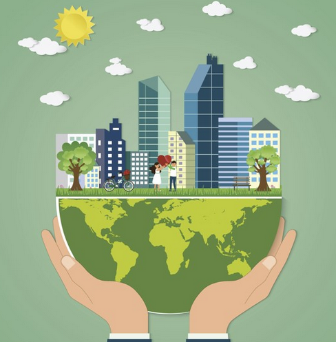Hands holding a globe with a city and green landscape
